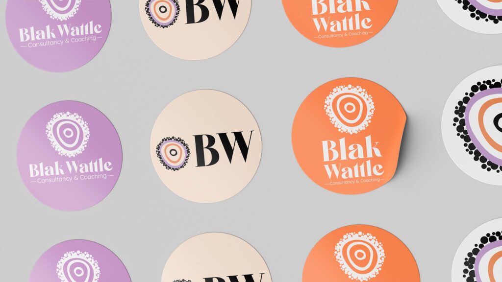 A group of stickers with a black, orange and purple organic logo and Blak Wattle written.