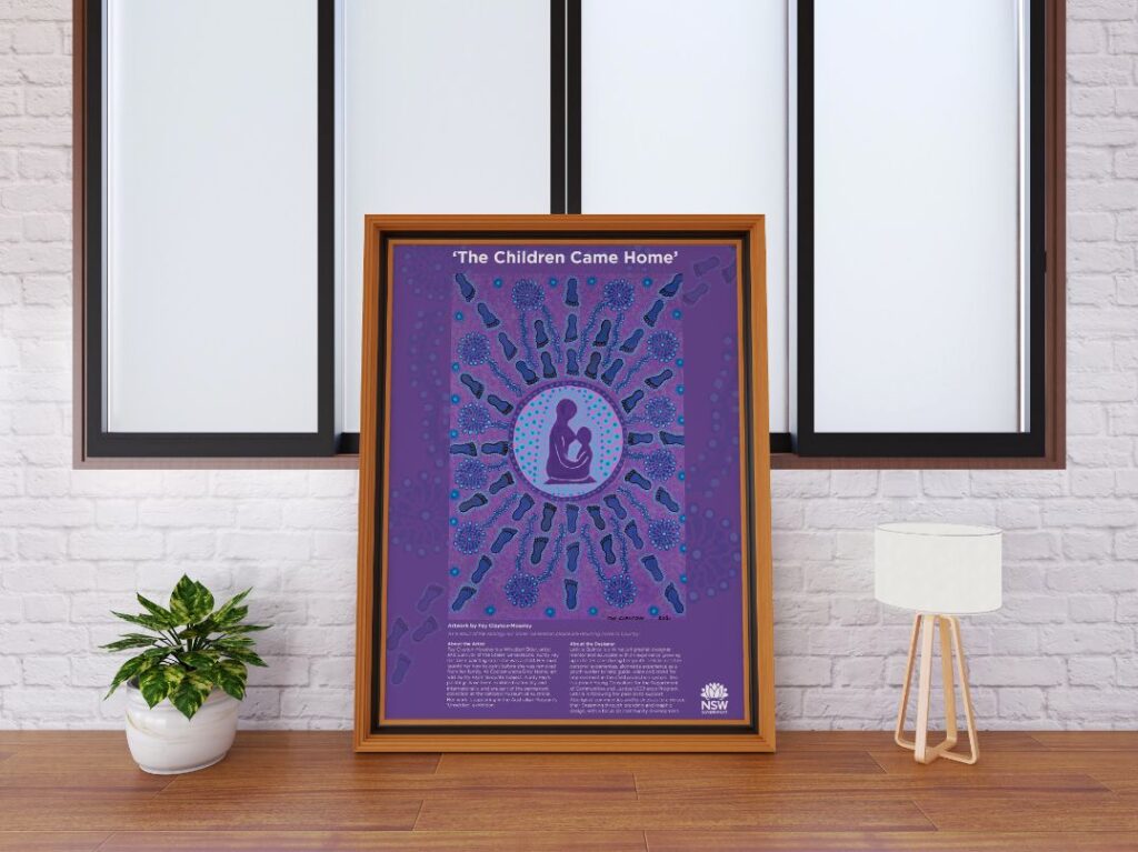 A large framed artwork sitting on the floor. The artwork is purple with two people in the middle and the caption 'The Children Came Home'.