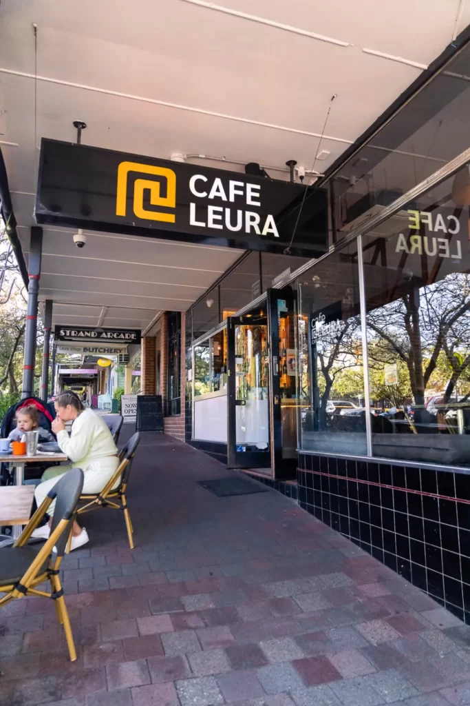 Cafe Leura logo on a sign in front of a cafe building.