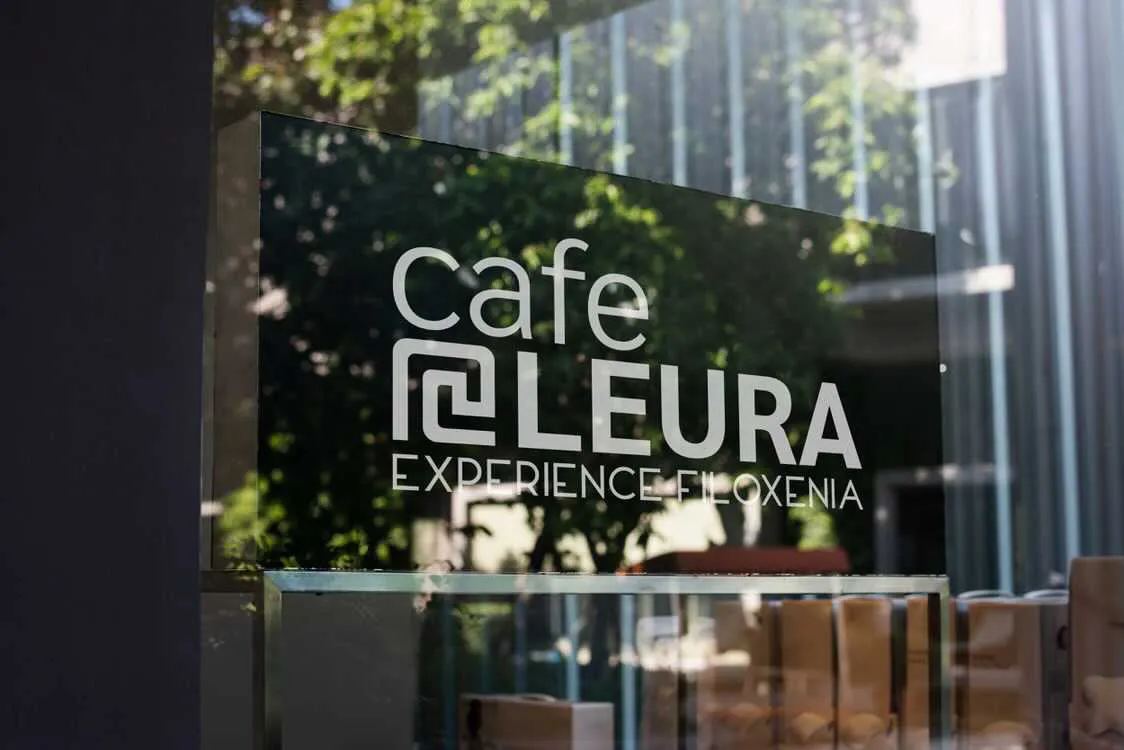 A window with the Cafe Leura Experience Filoxenia logo on it.