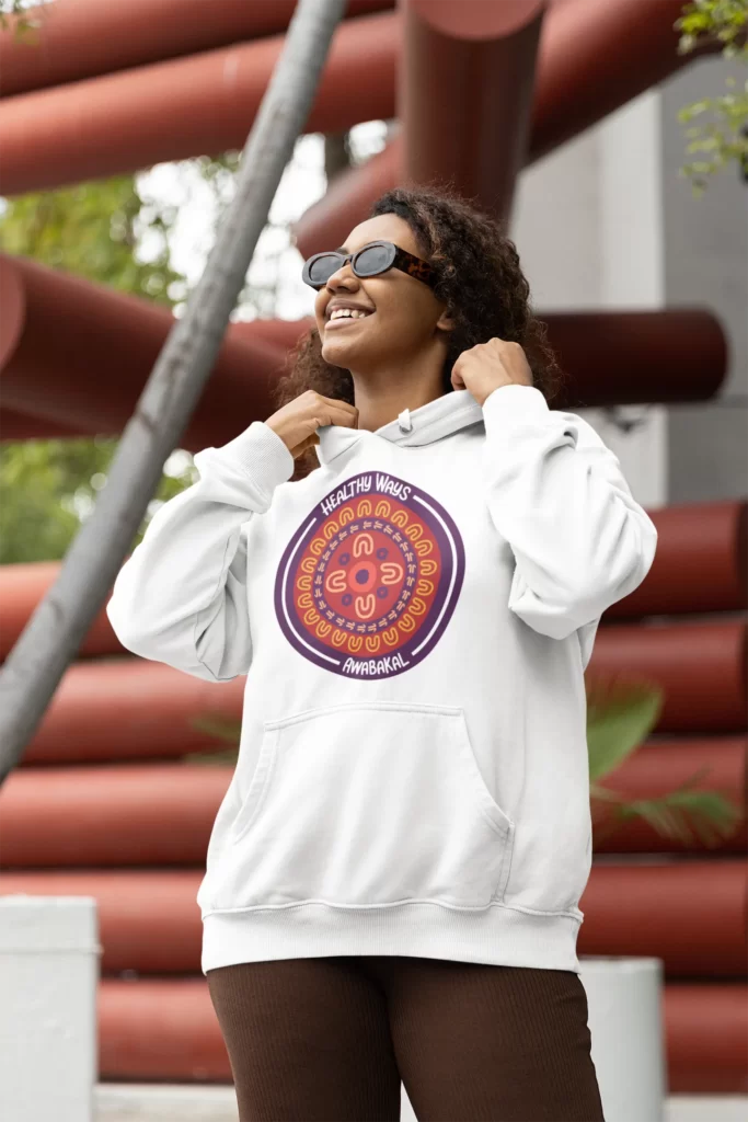 A woman with a white hoodie and a Healthy Ways Awabakal icon with an Aboriginal design